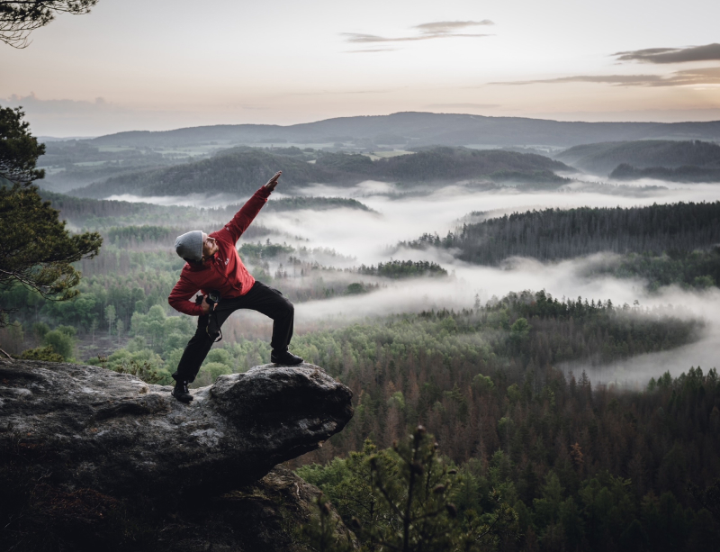 Tom sitting on a rock above a cloud forest